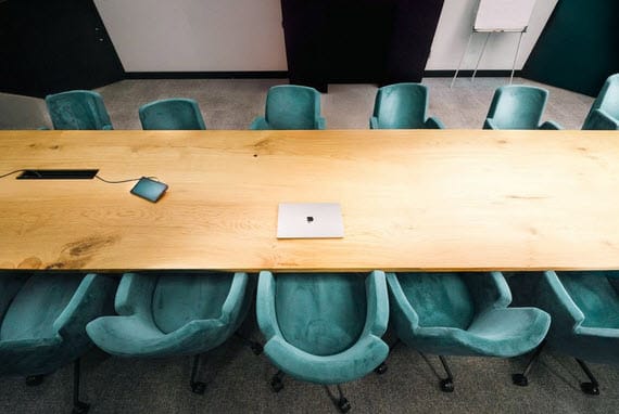 A solid wood conference table in a modern boardroom